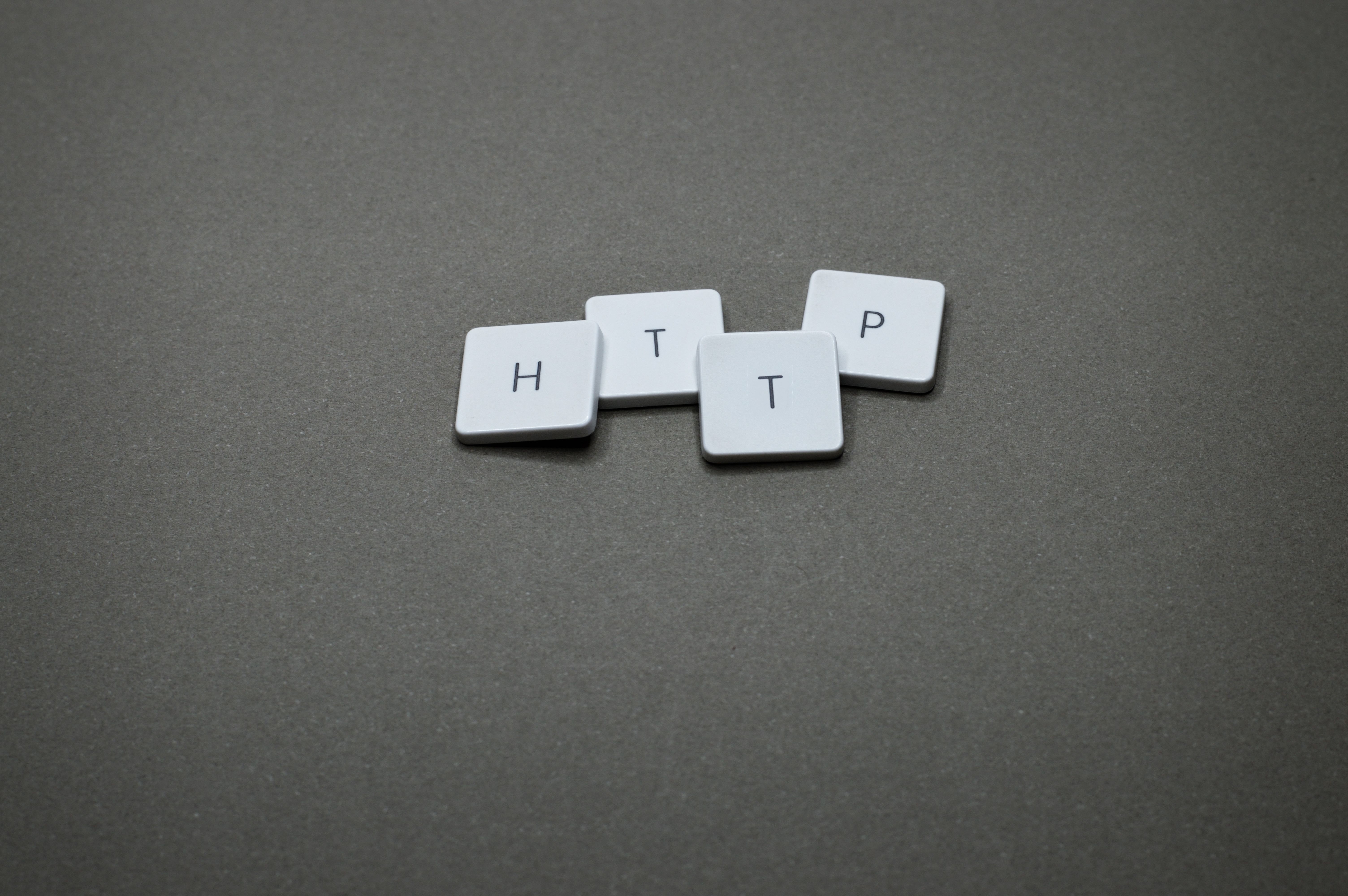High-angle photo of keyboard tiles spelling HTTP on a dark background.