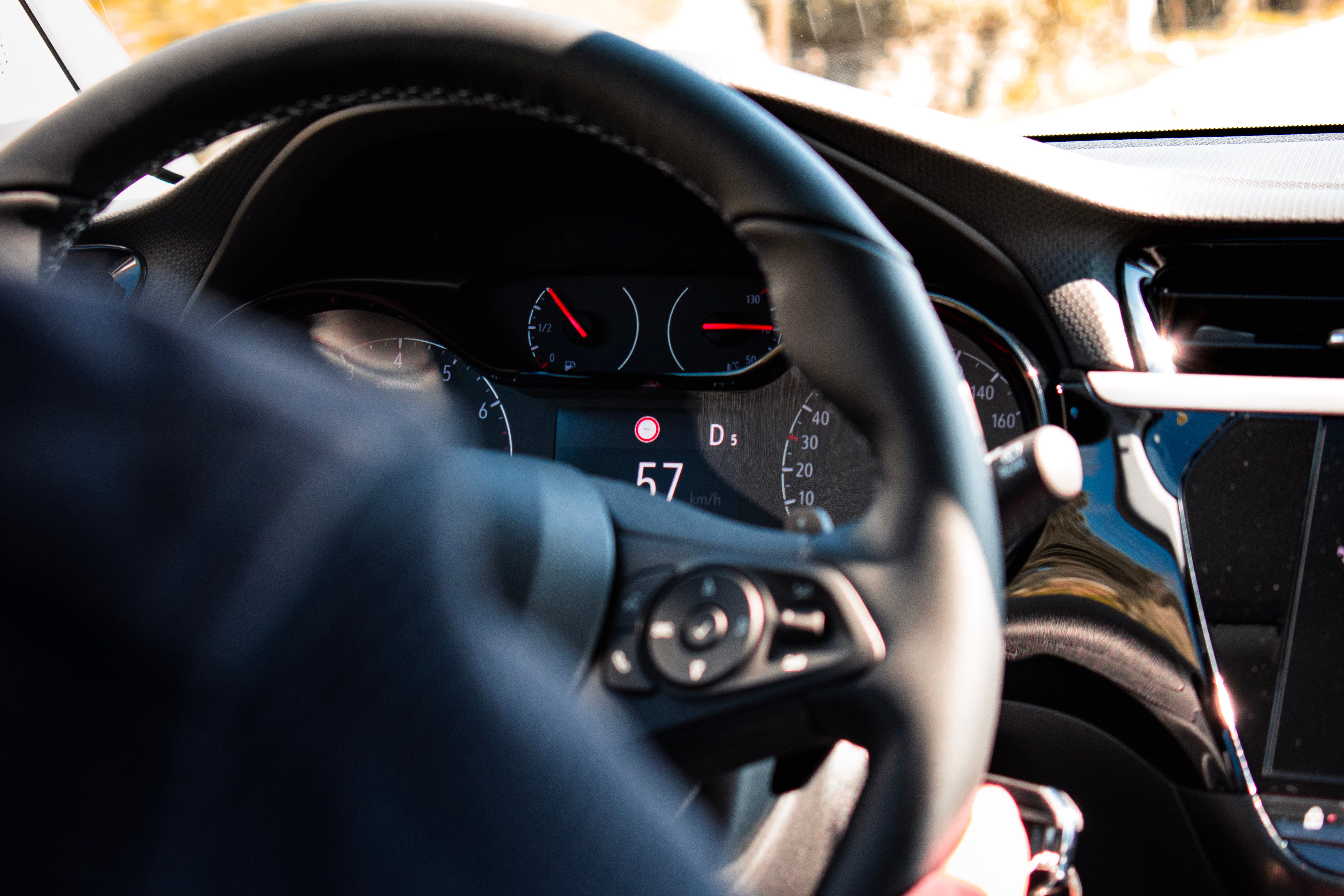 Close-up view of a car dashboard and steering wheel, featuring a digital speedometer display.