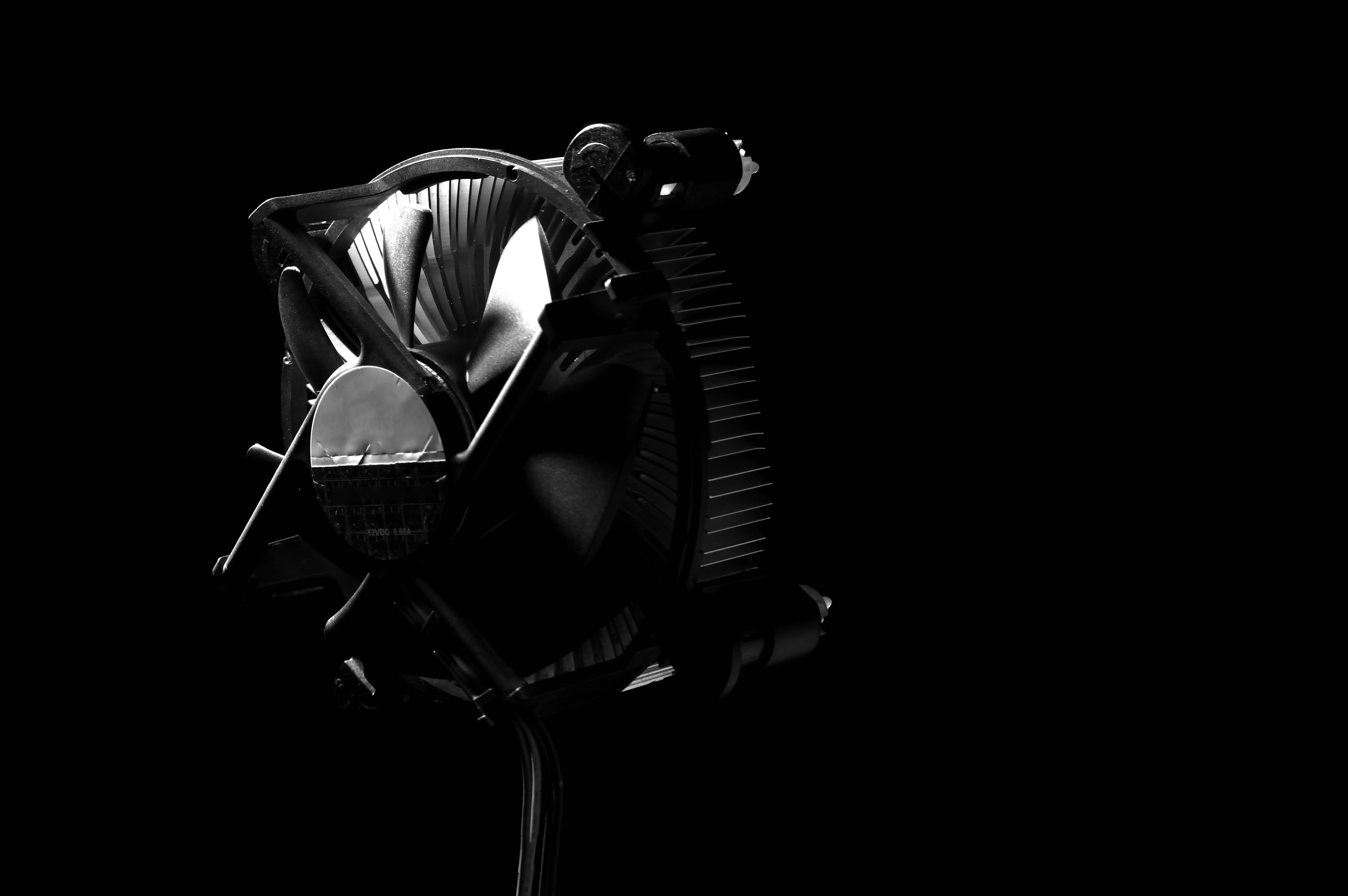 Elegant black and white photo of a CPU cooler with dramatic shadows, perfect for technology themes.