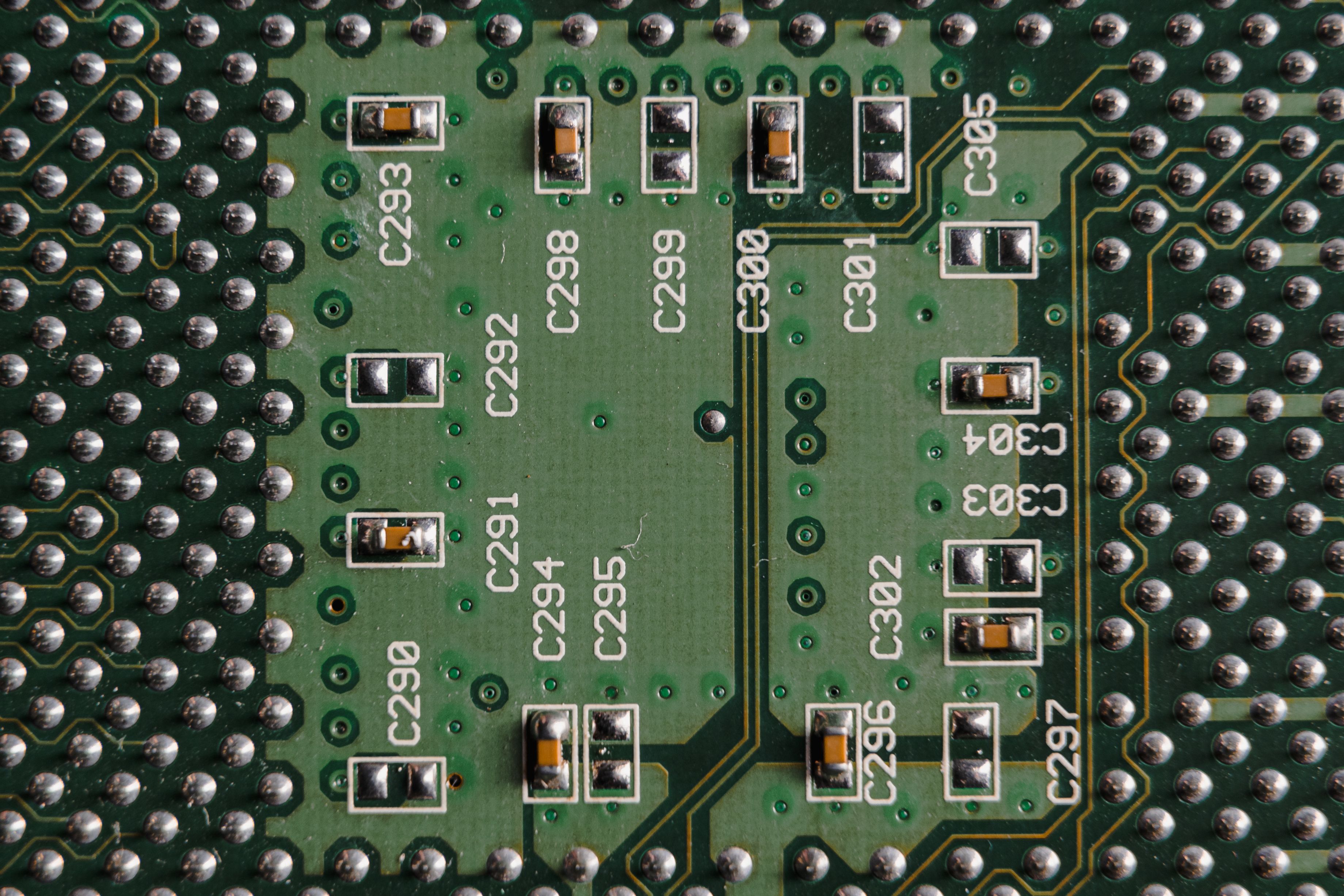 Detailed close-up of a green circuit board featuring microchips and labeled components.